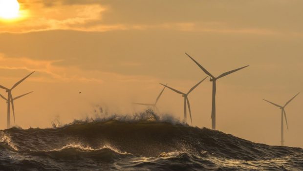Offshore wind turbines behind large waves.