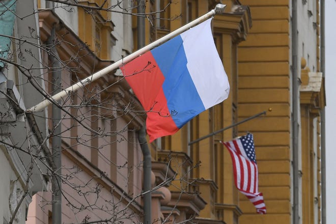A Russian flag flies next to the U.S. Embassy in Moscow. Cybersecurity professionals urge Americans to protect themselves from possible Russian cyber attacks.