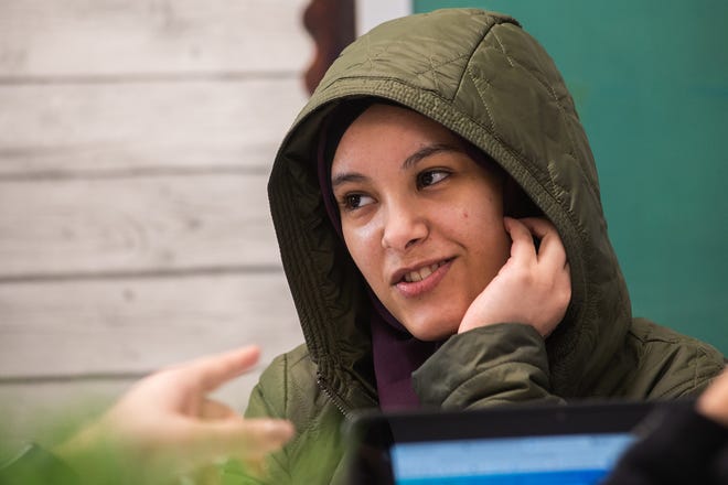 Hanan Ali, 16, listens through an earpiece that is translating what her teacher is saying from English to Arabic in real time during her class recently at South Middle School in Newburgh.