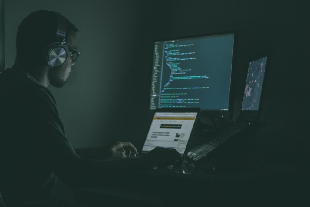 Image of a man coding on a computer.