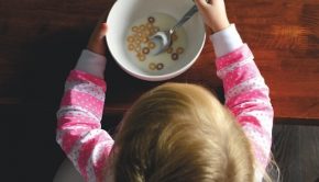 overhead photograph of a child with an almost empty cereal bowl