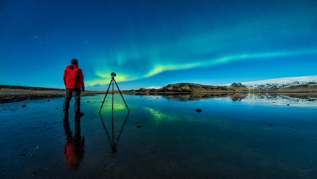 climate research - photo of a man taking a photo of the Northern Lights