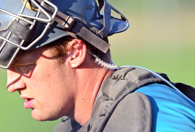 Brewster catcher Kurtis Byrne wears an earpiece to receive guidance from the bench about pitching calls against Y-D Cape League. The Whitecaps is the only team in the Cape Cod League employing the technology this season.