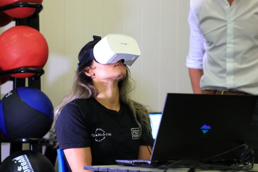 A woman with dark hair, looking up while wearing a VR headset.
