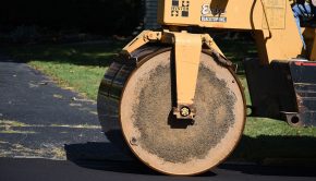 A vibratory roller compacts the road bed.