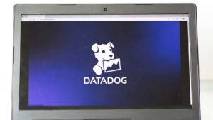 The Datadog (DDOG) logo displayed on a laptop screen.