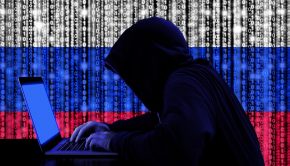 Russian hackers in a dark hoody sitting in front of a notebook with digital Russian flag and binary streams background showing cybersecurity advisory warning